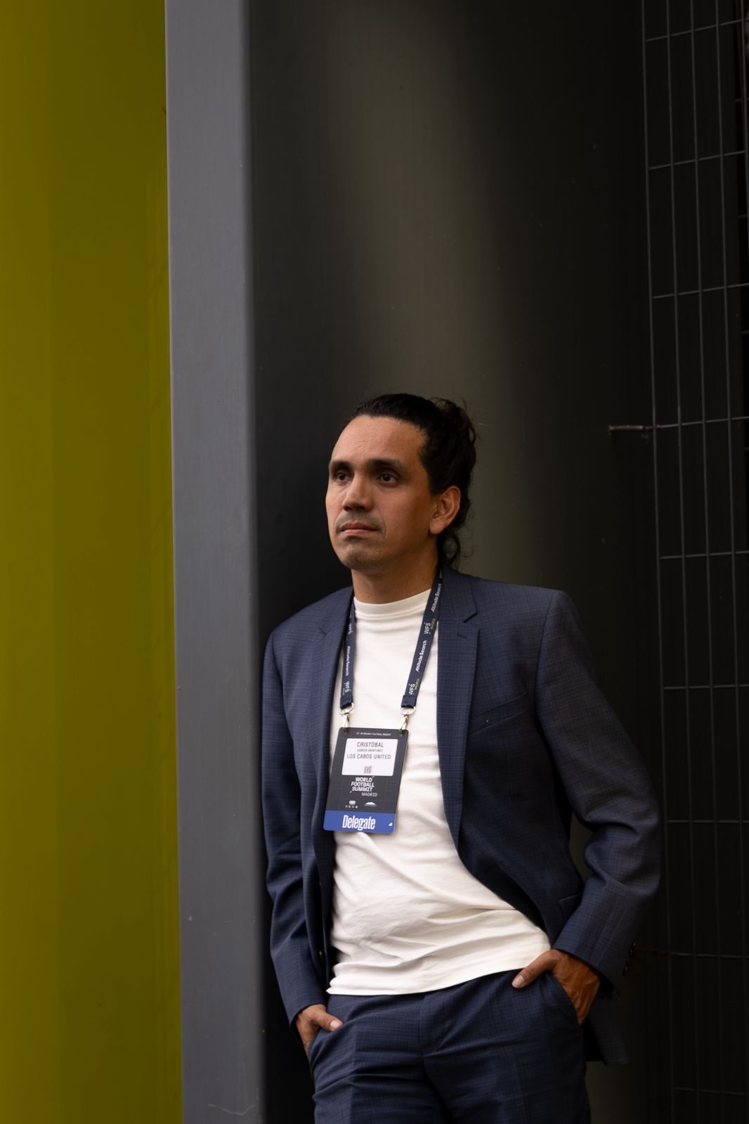 A man wearing a football-industry conference badge at a World Football Summit event